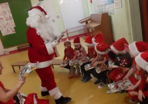 Mikołaj wręcza prezenty dzieciom z grupy Motylki.